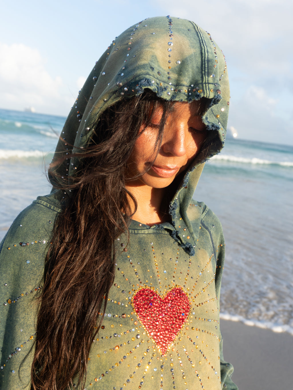 Close-up of the Unconditional Love oversized hoodie featuring rhinestone heart artwork, distressed details, and hand acid-washed fabric.